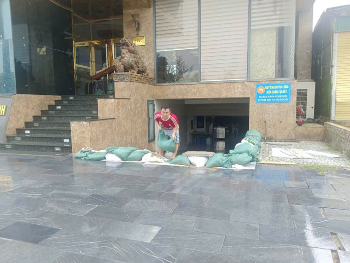 Người dân đắp bao cát ngăn nước biển tràn vào một khách sạn khi bão số 10 sắp đổ bộ ở phường Cửa Lò
